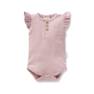 Alt text: A close-up image of a woman wearing a Dawn Pink Rib Bodysuit, featuring a scoop neckline and slim-fit design, perfect for everyday wear or layering